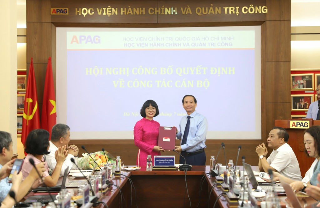 PGS.TS. Nguyễn Bá Chiến, Giám đốc Học viện Hành chính và Quản trị công trao quyết định, tặng hoa chúc mừng đồng chí Bùi Thị Thanh Thuý